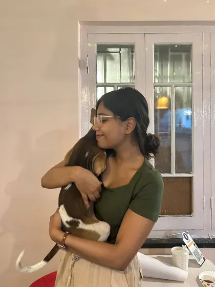 A participant closes her eyes, enjoying a peaceful cuddle with a beagle-mix puppy. The relaxed atmosphere of our events helps bring out the calm and loving nature of the shelter animals.