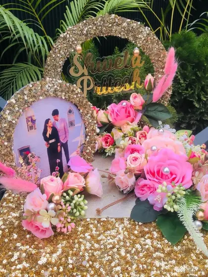 A beautiful engagement ring platter decorated with pink flowers and a personalized photo frame. The glittery base adds a touch of sparkle to the ceremony.