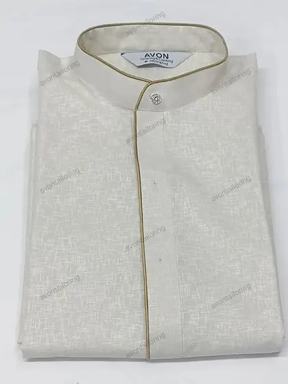 This off-white textured kurta is paired with a subtle golden piping. It is sold as a complete set with a matching saya and izaar.