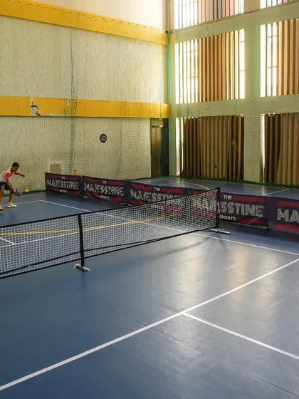 A wide view of a pickleball rally in action. Our premium court provides the perfect surface for this fast-paced and exciting sport.
