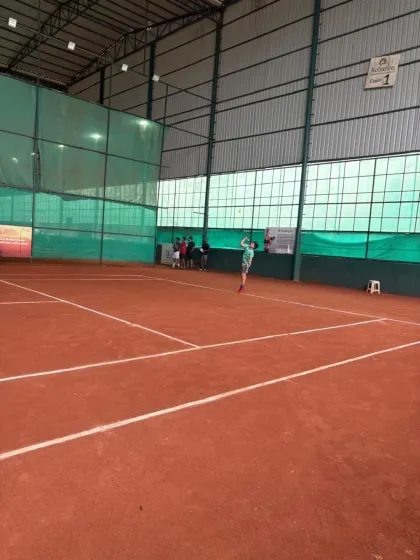 A player launching into a powerful serve during the inter-academy tournament.
