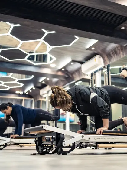 This image captures the intensity and control required for this kneeling plank variation. The entire class is focused, demonstrating the mind-body connection that is central to Pilates.