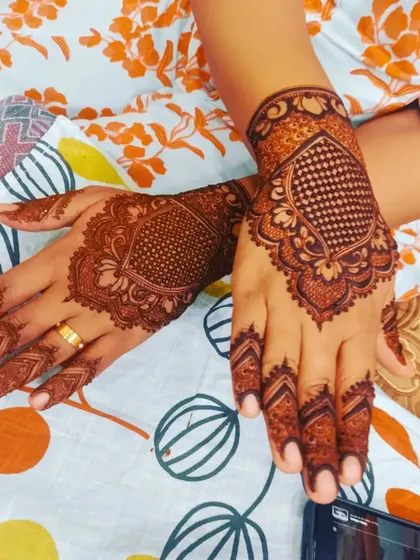 A beautiful Pakistani style design with a central filled mandala and detailed finger work. A classic and elegant choice.