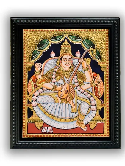 The framed Saraswati Tanjore painting, a perfect source of inspiration for a study or creative space. The artwork embodies the pursuit of wisdom and artistic excellence.