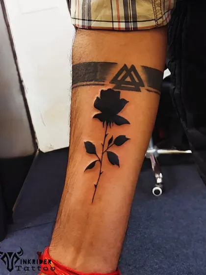 After: We reworked the armband with solid black ink and covered the lower portion with a striking black silhouette of a rose, creating a modern and high-contrast negative space tattoo.