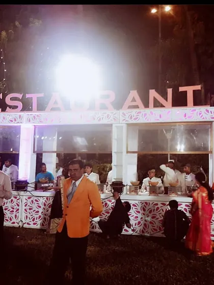 For this outdoor wedding, we created a full "Restaurant" experience with distinct, well-lit counters for different cuisines, allowing guests to explore a world of flavors.