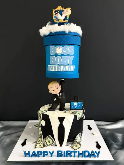 A full view of the gravity-defying Boss Baby cake, showing how the top tier seems to float, held up by the tiny but mighty Boss Baby himself.
