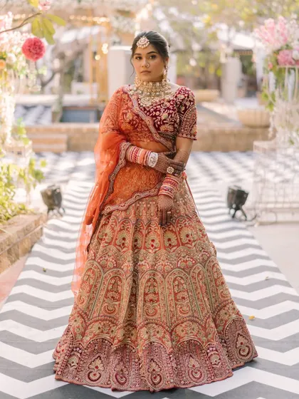 A powerful and confident pose from the bride. The makeup is bold and striking, matching the regal energy of her entire look.