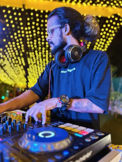 A profile shot of me mixing at an outdoor wedding reception, with beautiful string lights in the background.