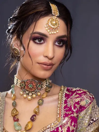 A close-up of a regal bridal look with a purple smokey eye. I encourage my students to experiment with color to create unique and personalized looks for their brides.