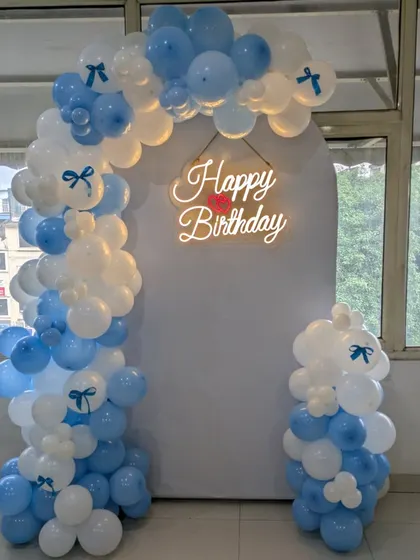 The little bow details on the balloons add a charming and cute element to this blue and white setup.