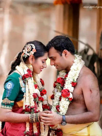 A beautiful, soft-focused portrait of the couple sharing an intimate moment. The traditional attire and garlands add to the timeless feel of this wedding photograph.