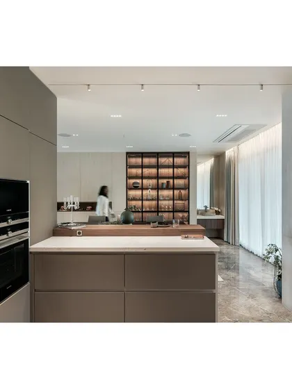 Another perspective of the kitchen and dining area, showing how the different zones are defined by flooring and lighting while remaining visually connected.