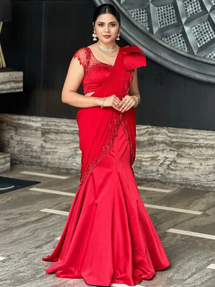 When you glow with love, you glow differently. This client is a vision in red, her modern, mermaid-style saree gown paired with a sleek ponytail and elegant diamond jewellery.