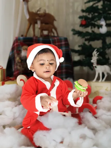 Playing in the 'snow'! This candid shot captures a child's playful interaction with the props during our fun-filled Christmas photoshoot.