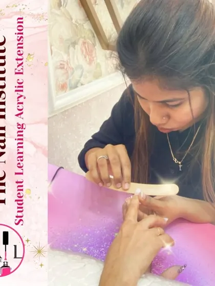 A student carefully files and shapes an acrylic extension, ensuring the final result is smooth and perfectly contoured.