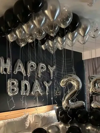 A classic and stylish room setup for a 25th birthday. Black and silver balloons on the ceiling, "HAPPY BDAY" foil letters, and large number balloons create an instant party vibe.