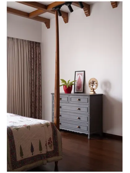 We kept the wall opposite the bed deliberately bare, with just a simple chest of drawers, to bring a sense of quiet and peace. This balances the ornate, four-poster bed on the other side.