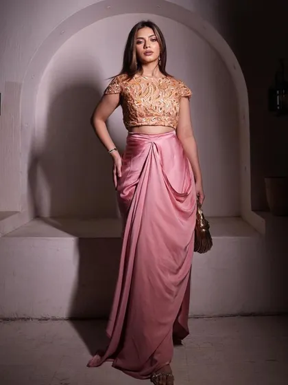 Nagma Mirajkar makes a statement in this peach embroidered blouse and shimmer drape skirt.