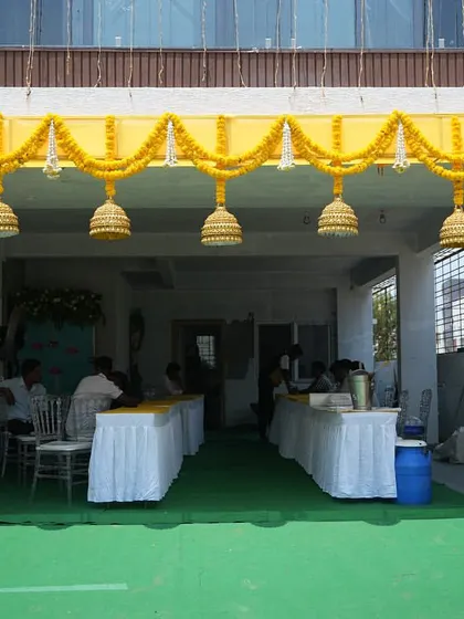 The entrance to the "Kanasi" housewarming, decorated with traditional yellow marigold garlands and temple bells. This setup created a warm and auspicious welcome for all the guests celebrating the new home.