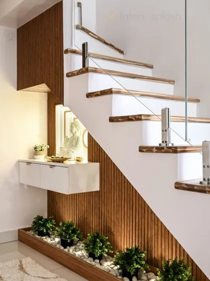 This foyer design makes clever use of the space under the stairs. A floating console with a Buddha statue and a small planter with pebbles creates a beautiful and tranquil corner.