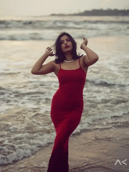 A collection of portraits featuring a model in a red dress on the rocks and by the water. The series explores different poses and moods, from serene to powerful.