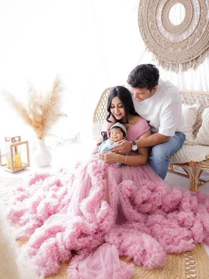 A duplicate of image 6, this portrait captures the tender moment of new parents admiring their sleeping newborn in a beautiful boho setting.