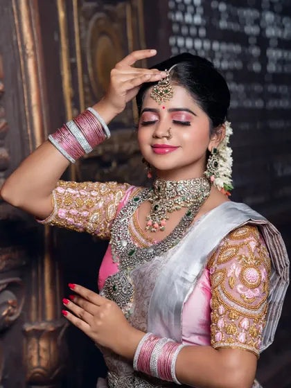 A serene close-up with eyes closed, focusing on the makeup and the beautiful maang tikka.