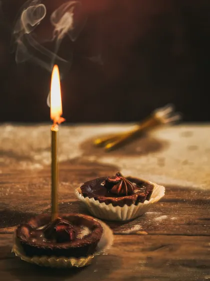 A creative shot capturing the smoke wafting from a just-extinguished candle on the birthday tart.