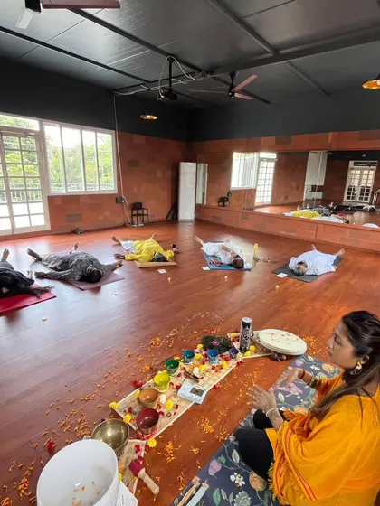 A wide view of a sound bath in a beautiful studio. You can see participants resting peacefully as I sit with my instruments, guiding the flow of energy and sound through the room.