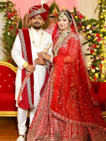 A full-length shot showcasing the bride's complete look, from the detailed makeup and jewelry to the beautifully draped red lehenga.