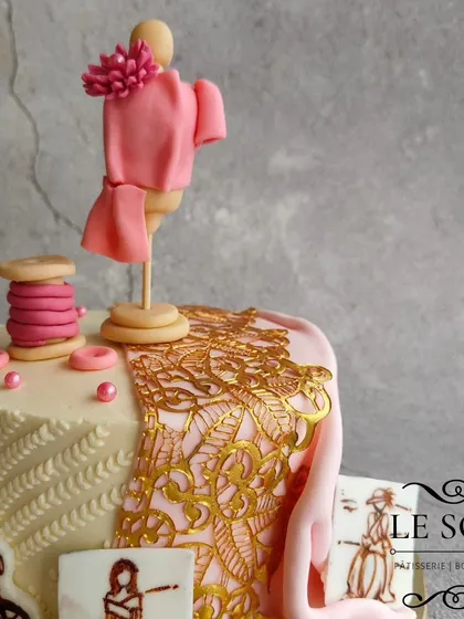 This cake celebrates a fashion designer's dream. The half-kg Milk Chocolate Truffle cake is decorated with a mannequin, a thread spool, sketches, and a beautiful gold lace fabric effect.