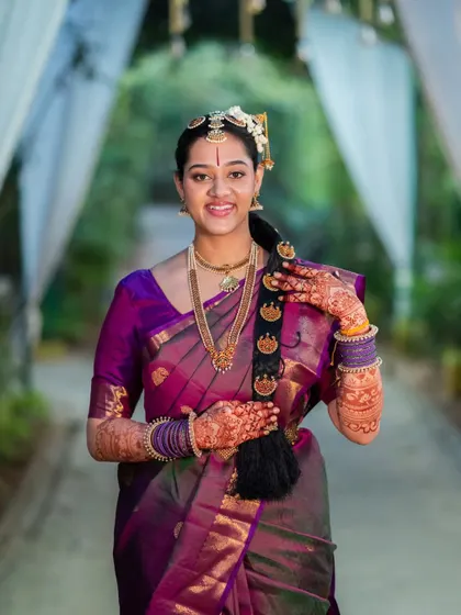 The beautiful bride Sahana, her hands adorned with a rich, dark mehendi stain that perfectly matches her elegant bridal look.