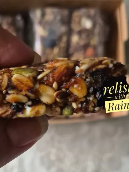 A close look at one of my homemade Granola Bars. It's packed with rolled oats, various nuts, seeds, and dried fruits, all bound together. This version is sweetened naturally with dates.
