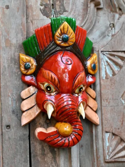 A traditional Ganesha mask from Nepal, hand-carved and painted with bright, natural colors. As the remover of obstacles, this mask is not just a decorative piece but a symbol of auspicious beginnings.