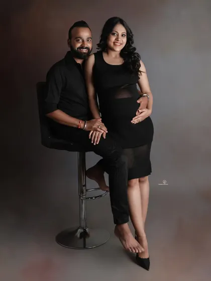 A chic and modern studio portrait of an expecting couple. Coordinated black outfits create a sleek and timeless look that puts all the focus on their connection and the baby bump.