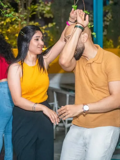 A playful move under the hanging greenery. The venue's ambiance adds to the unique experience.