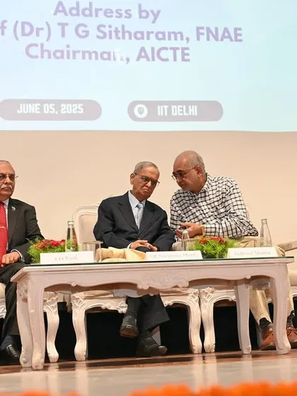 A candid moment of discussion between the dignitaries on stage. These unposed shots often reveal the collaborative spirit of an event.