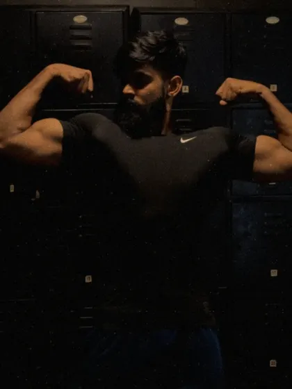 "The mind is the most important part of achieving any fitness goal." A double bicep pose in a dark, moody setting.