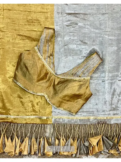 A gold and silver tissue saree with dramatic tassels, which we paired with a chic sleeveless, ruched blouse with metal sequin accents.