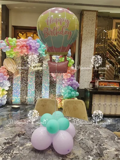 A hot air balloon foil balloon makes a cheerful and thematic centerpiece for a high-flying birthday adventure.