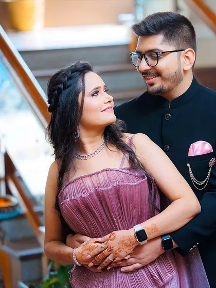 A classic engagement portrait of the couple embracing on a staircase. This pose is both elegant and intimate, showcasing their connection and beautiful outfits.