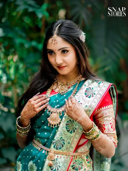 A beautiful South Indian bride adjusting her traditional jewelry. We capture the elegance and richness of cultural bridal attire.