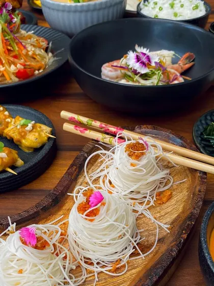 An artful presentation of rice noodles alongside other Thai delicacies, showcasing the diverse textures and flavors of our 'Bangkok Joes' menu.