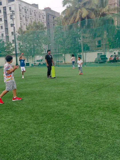 A snapshot from a cricket and football mashup party, showing kids enjoying a game of cricket on the turf.