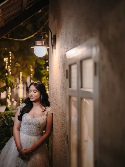 A beautiful portrait of Pooja by the window, with the warm evening lights creating a romantic ambiance for her reception.