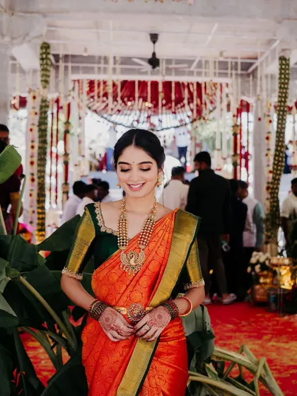 The client at a wedding function, looking graceful and elegant in her custom-designed outfit.