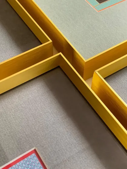 A close-up of the clean lines and sharp corners of our gold metal frames, demonstrating the quality and precision of our craftsmanship.