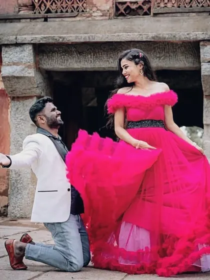 When he'll do anything to see her smile. A playful and romantic moment captured with her in our dramatic pink ruffle gown.