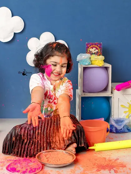 This toddler is having a blast playing with safe, organic colors during our Holi mini session. Her joyful expression says it all.